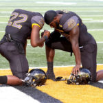 Jay'Shawn Washington and C. J. Perry of Southern Miss share a moment of prayer prior to game against Charlotte. 

Photographer's Comment - This was a nice moment prior to the start of the football game. A photographer will keep an eye for personal moments that might otherwise go unnoticed.