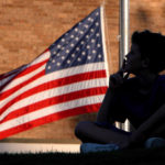 Jessie Fishbaugh is silhouetted against the U. S. flag as he watches a 911 remembrance ceremony in Ocean Springs.